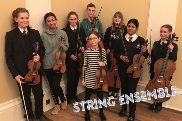 children posing with string instruments including violins and cello