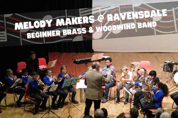 Beginner brass and woodwind players playing in concert